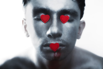 men in silver makeup with bruises and symbol of heart