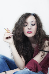 Fototapeta premium curly long-haired brunette woman with cigarette isolated