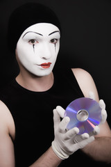 Portrait of mime with cd on black background