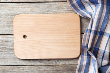 Empty wooden table with cutting board and napkin on grey backgro