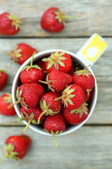 Strawberries berry in cup on grey wooden background