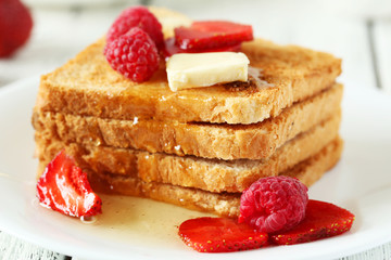 Fresh toast with raspberry and strawberry on white wooden backgr