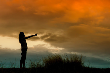 woman standing alone at the field during beautiful sunset
