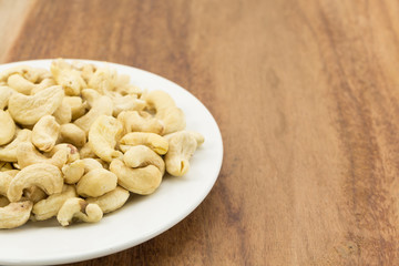 Cashew nuts on a rustic wooden against  wood background