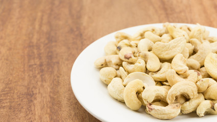 Cashew nuts on a rustic wooden against  wood background