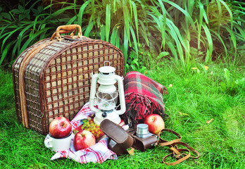 Picnic basket with vintage objects, outdoors, selective focus
