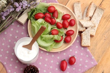 Fototapeta na wymiar White yogurt and fresh cherry tomatoes
