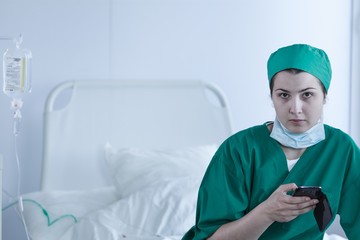Surgeon sitting on empty bed