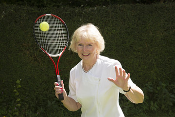 Elderly woman playing tennis