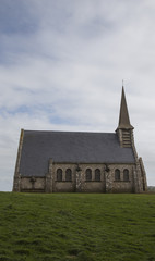 Fototapeta na wymiar Church on hill at Etretat during sunset