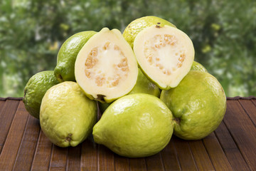 A white guava cut in a alf in over some entire white guavas over