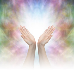 Divine Healing Energy - Female healing hands outstretched with misty white graduated light on a beautiful delicate multicolored energy field background