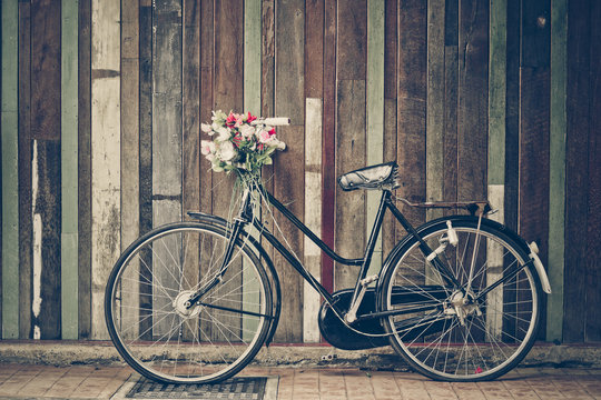 old classic bicycle parked in front of a wood plank wall