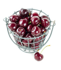 cherries in metallic basket isolated on white