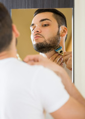 Fototapeta premium Man shaving the beard with a razor