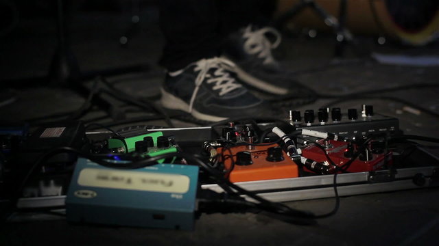 Close up of guitar players foot pressing pedal board