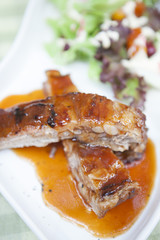 Pork rib stack with red sauce with salad