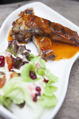 Pork rib stack with red sauce with salad