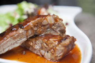 Pork rib stack with red sauce with salad