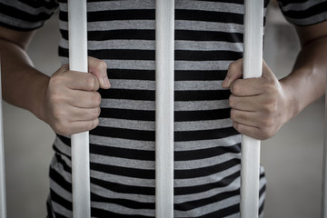 The Asian prisoner standing behind the jail