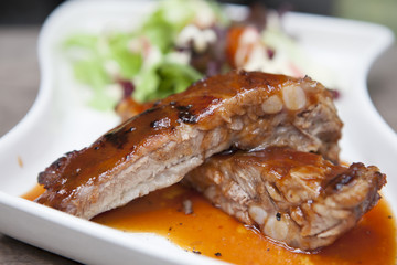 Pork rib stack with red sauce with salad