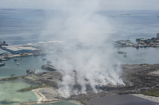 Burning garbage heap of smoke from a burning pile of garbage on island in the Maldives, .showing thick smoke rising from burning piles of waste, highlighting the critical environmental issue.