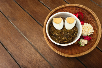 Thai food pound eggplant with boiled egg on wood table