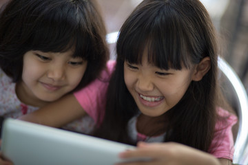 Close up of Asian child using tablet together