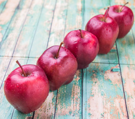 Red apple fruits over weathered wooden background