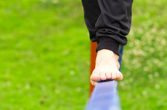 Closeup Of Mans Feet Balancing A Tightrope Or Slackline In Park Environment