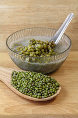 Mung beans in a wooden spoon and Mung bean boiled in a bowl on wooden background