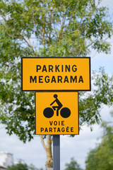Parking Megarama and shared lane with cyclists signs outside car