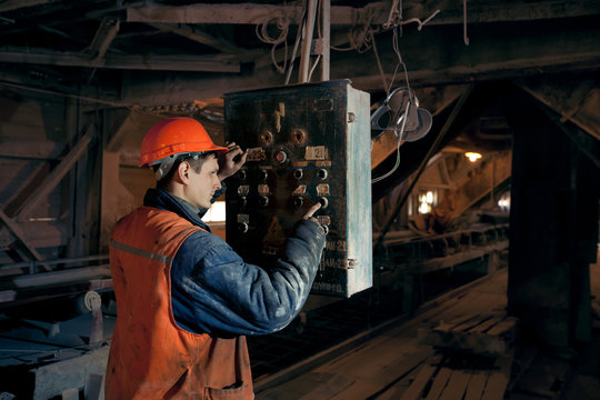 Miner worker man in a helmet at the control operator of the mine.