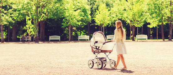 happy mother with stroller in park