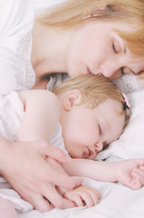 little sleeping baby girl with her caring mother