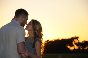 romantic sensual young couple in love posing at the sunset