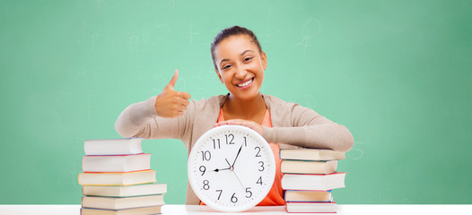 african student girl with books and clock