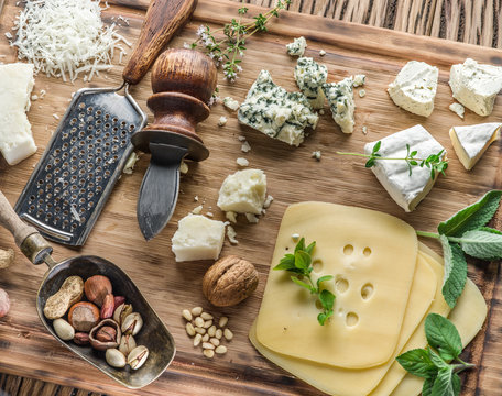 Different types of cheeses with nuts and herbs.