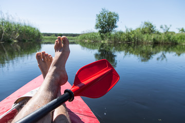 Man's legs over canoe. Resting time.