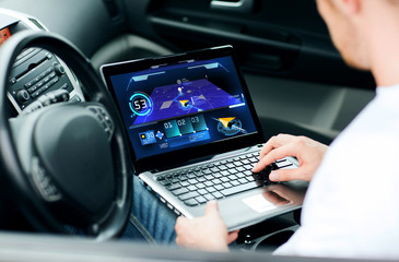 man using navigation on laptop computer in car