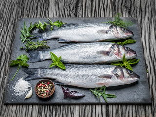 Seabass on a graphite board with spices and herbs.