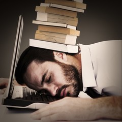 Composite image of businessman resting head on laptop keyboard