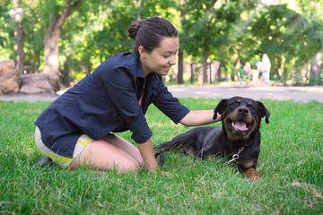 A beautiful woman walks in the park Rottweiler