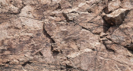 Rough brown rock wall, stone texture