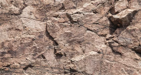 Fototapete Steine Rough brown rock wall, stone texture