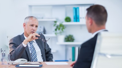 Two serious businessmen speaking and working 