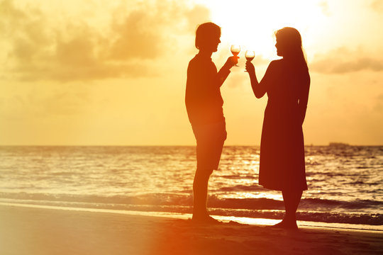 Silhouette of couple drinking wine at sunset