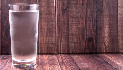 A glass of water over wooden background