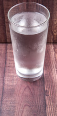 A glass of water over wooden background