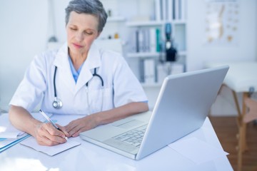 Female doctor writing on paper 